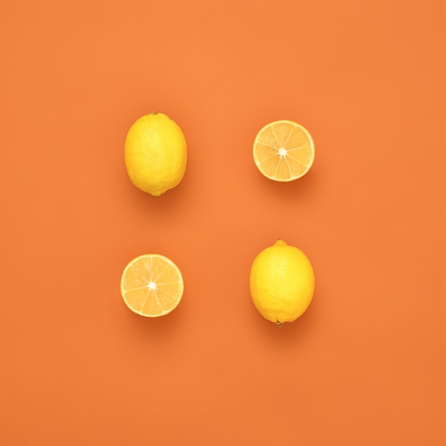 Frische Zitronen auf orangefarbenem Hintergrund Kreatives Layout der Zitrone Flaches Lebensmittelkonzept