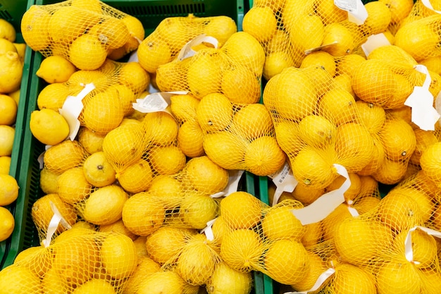 Frische Zitronen in Fabriknetzen auf der Theke im Laden.