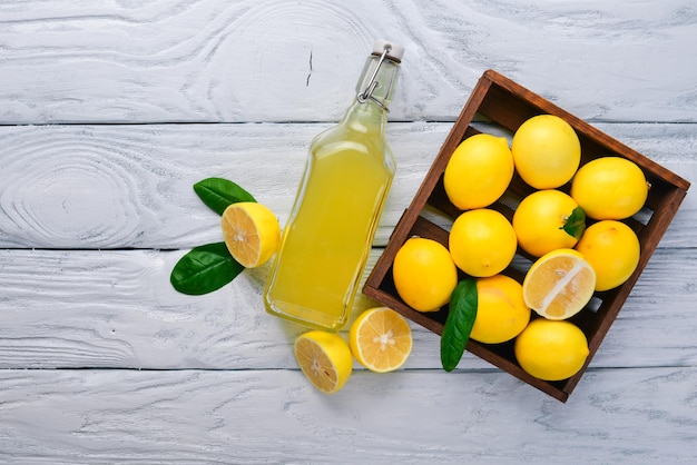 Frische Zitronen und Zitronensaft auf einem hölzernen Hintergrund Ansicht von oben Freier Platz für Ihren Text