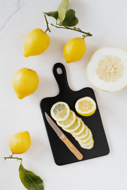 Frische Zitronenscheiben auf einem schwarzen Schneidebrett-Flatlay