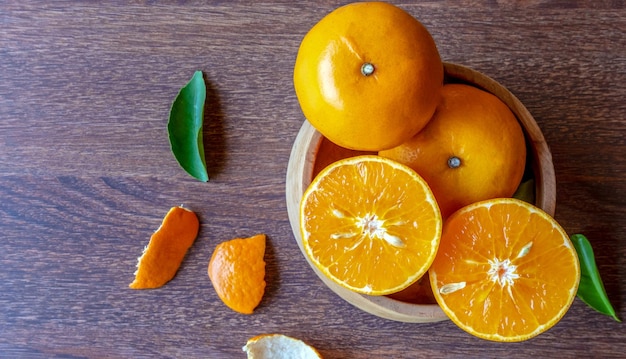Frische Zitrusfrüchte halbiert auf einer Holzschale Draufsicht auf Orangenfrüchte