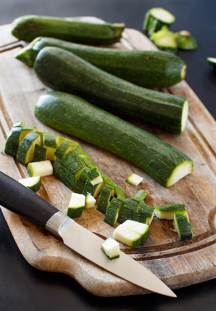 Frische Zucchini auf einem Holzbrett mit einem Messer