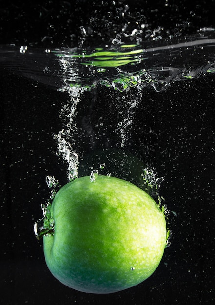 Frischer Apfel, der in Wasser fällt