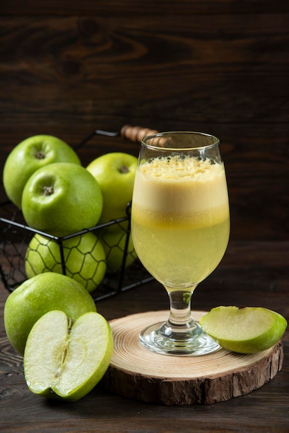 Frischer Apfelsaft mit frischem Apfel auf dunklem Hintergrund der Holzplatte