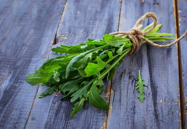 Frischer Arugula auf hölzernem Hintergrund