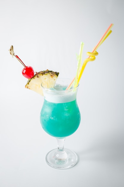 Frischer blauer Curaçao-Coctail des Alkohols mit Ananas und Beere auf weißem Hintergrund.