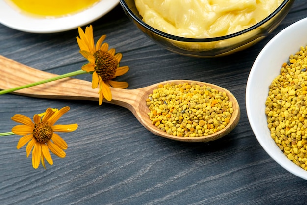 Frischer Blumenhonig verschiedener Sorten, Pollen mit Löffeln auf Holzhintergrund. Bio-Vitamin-Gesundheitsnahrung