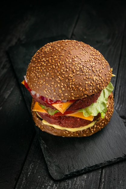 Frischer Burger mit veganem Fleisch und Gemüse, bestreut mit Sesam