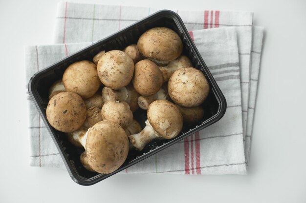 Frischer Champignons-Pilz in einer weißen Schüssel auf dem Tisch