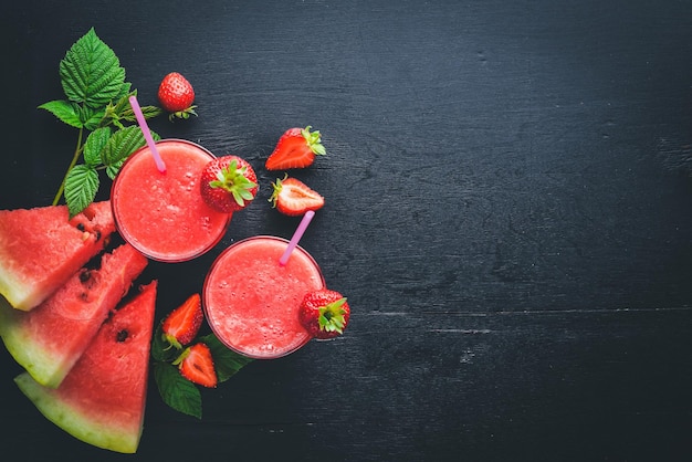 Frischer Cocktail aus Wassermelone und Erdbeeren Minzeis auf einem Holzbrett Draufsicht Freier Platz für Ihren Text