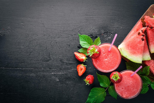 Frischer Cocktail aus Wassermelone und Erdbeeren Minzeis auf einem Holzbrett Draufsicht Freier Platz für Ihren Text