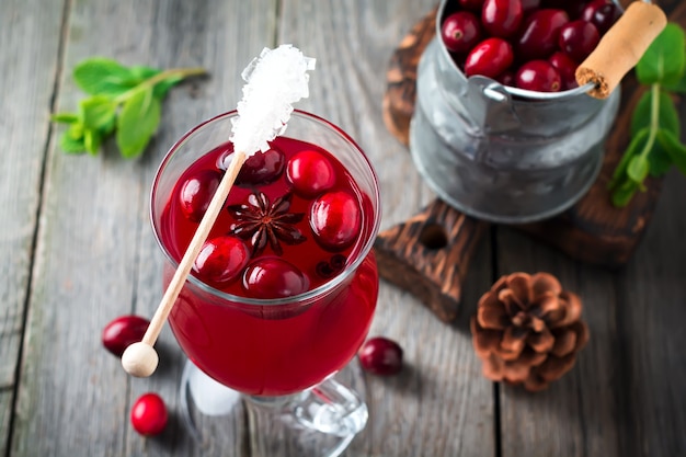 Frischer Cranberrysaft mit Zimt und Anis in Gläsern auf der alten Holzoberfläche. Selektiver Fokus. Draufsicht.