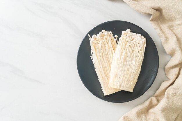 Frischer Enoki-Pilz oder goldene Nadelpilze auf Teller