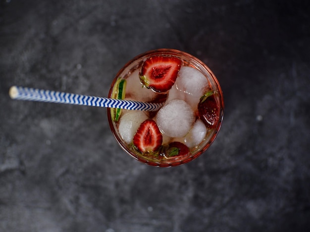 Frischer Erdbeercocktail mit Erdbeeren mit Gurkenstücken und mit Eis auf dunklem HintergrundDraufsicht Platz für Text