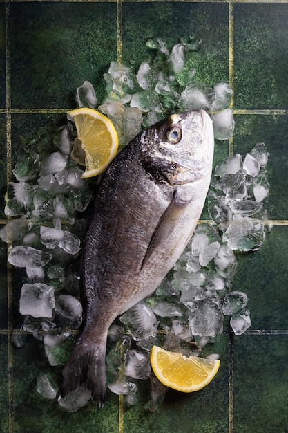 Foto frischer fisch-dorado mit zitrone auf eis