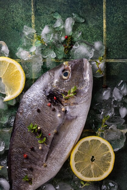 Foto frischer fisch-dorado mit zitrone auf eis