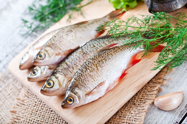 frischer Fisch mit Rosmarin auf Holzbrett