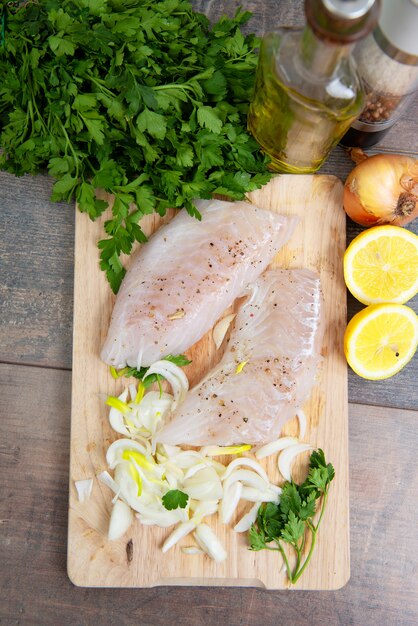 Frischer Fisch, rohe Kabeljaufilets mit Kräutern und Zitrone