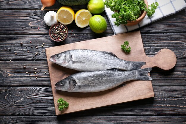 Frischer Fisch und Zutaten auf Holztisch