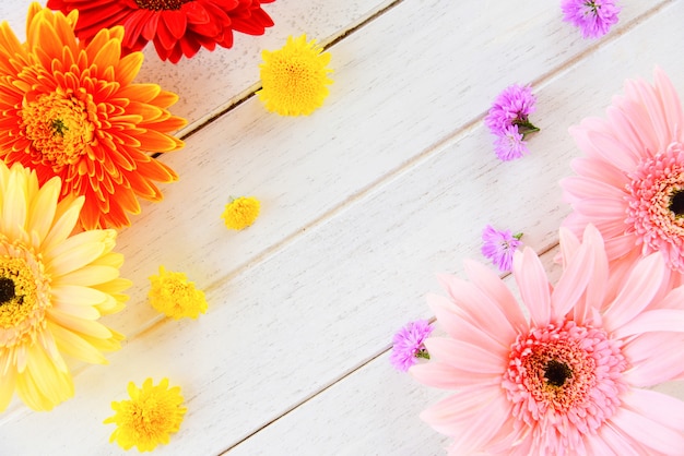 Frischer frühling blüht den bunten gerbera und die blume, die auf holztisch verschieden ist