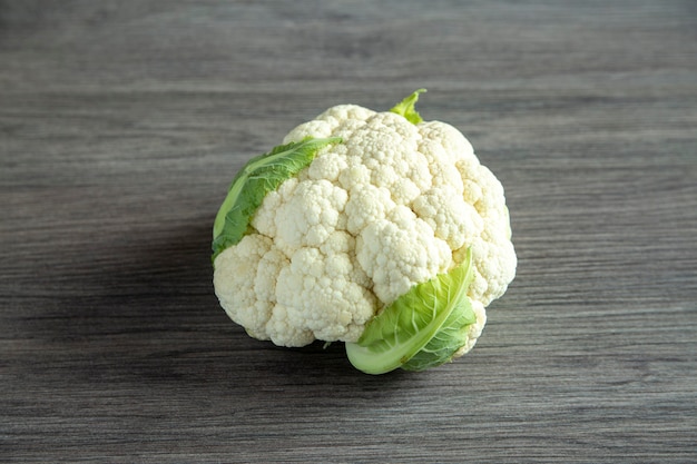 Frischer ganzer Blumenkohl auf einem Holztisch. Gesundes Essen.