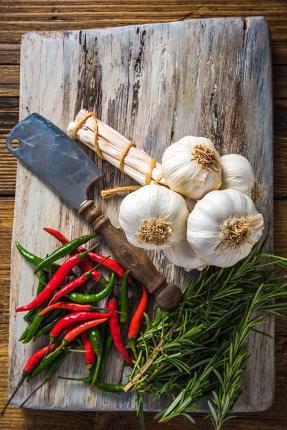 Frischer ganzer Knoblauch und Gewürze auf Schneidebrett