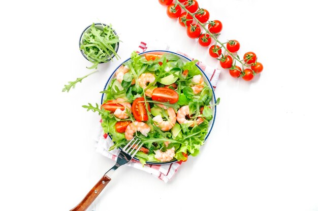 Frischer Garnelensalat mit Tomaten, Salat, Rucola, Avocado, Gurke und Zitronendressing auf weißem Hintergrund Gesunde Ernährung, sauberes Lebensmittelkonzept Draufsicht