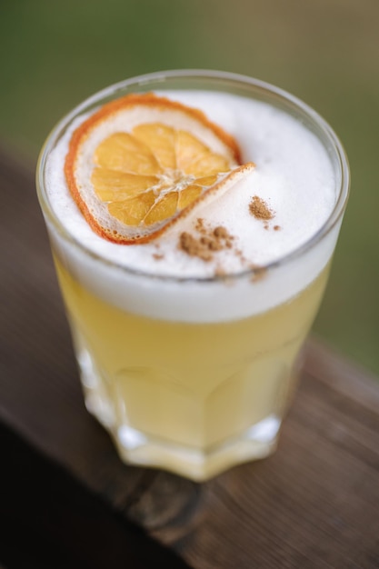 Frischer gelber Gin-Cocktail mit Tonic und Saft. Dekoriert mit einer Scheibe getrockneter Orange