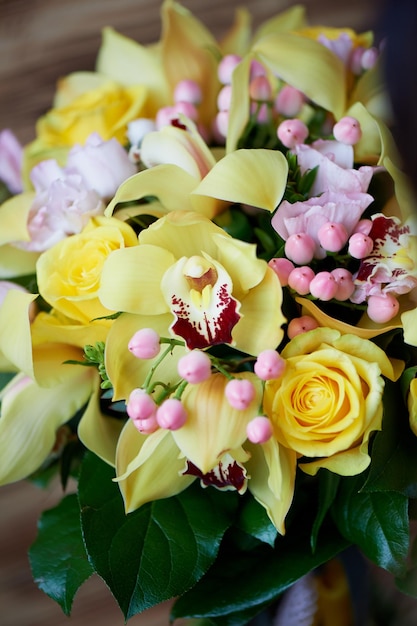 Frischer gelber Strauß aus gelben Rosen und rosa BeerenHelle Farben