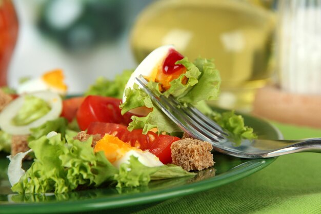 Frischer gemischter Salat mit Eiern, Tomatensalatblättern und anderem Gemüse auf Farbplatte auf hellem Hintergrund