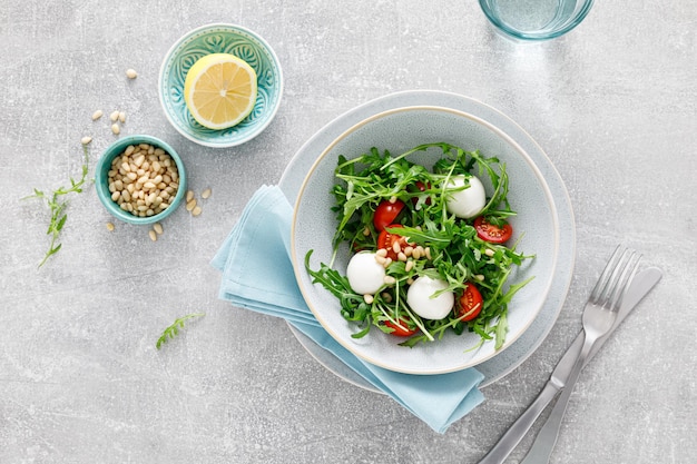 Frischer Gemüse-Caprese-Salat mit Arugula-Tomaten-Pinienkernen und Mini-Mozzarella-Käse Draufsicht