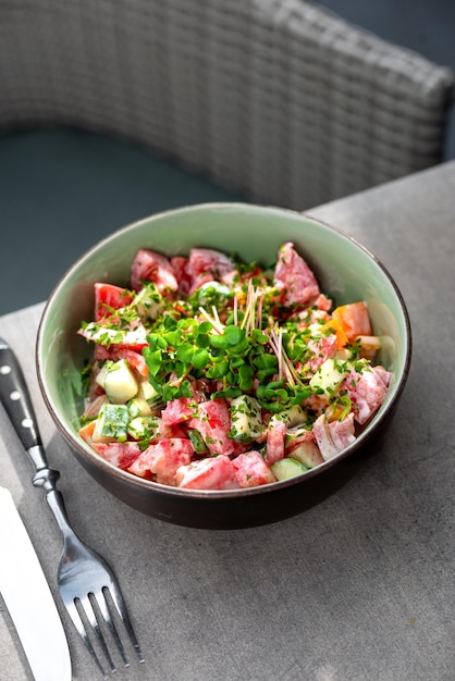 Frischer Gemüsesalat aus Tomaten und Gurken mit Sauerrahm in einem Teller