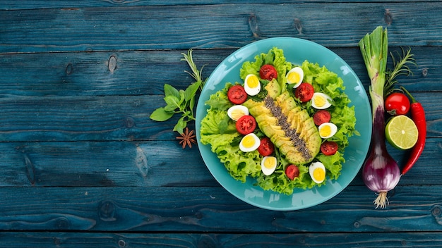 Frischer Gemüsesalat Avocado Kirschtomaten Kopfsalat Wachteleier Auf einem hölzernen Hintergrund Ansicht von oben Freier Kopierraum