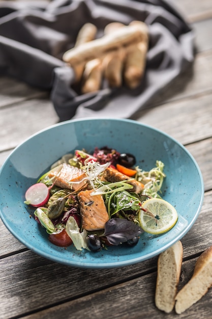 Frischer Gemüsesalat mit geröstetem Lachs-Olivenöl und Baguette.