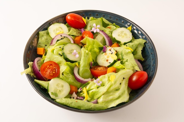 Frischer, gesunder, grüner Salat mit Tomaten und Gemüse im vorderen Blick, isolierter, sauberer Hintergrund