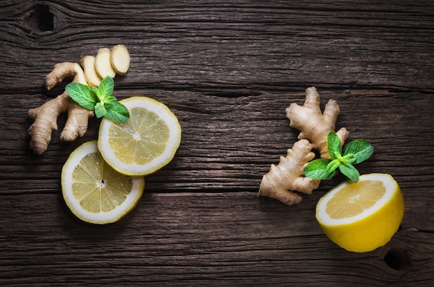 Frischer, gesunder Ingwer und reife Zitrone auf Holzhintergrund