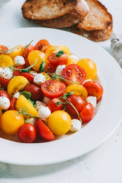 Frischer gesunder Salat mit Cherrytomaten, Mozzarella und Olivenöl