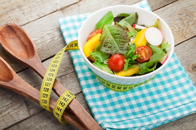 Frischer gesunder Salat und Küchenutensilien