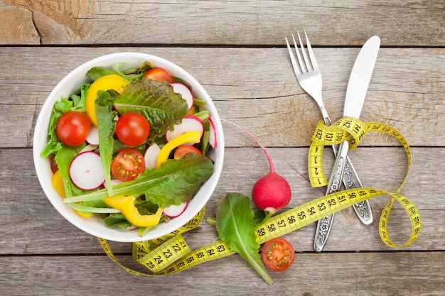 Frischer gesunder Salat und Maßband Gesundes Essen