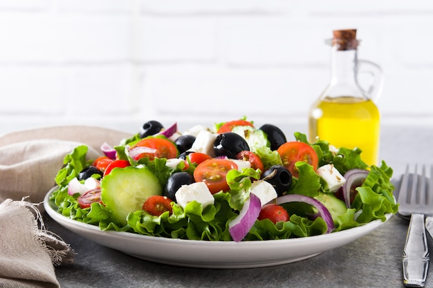 Frischer griechischer Salat in der Schüssel mit schwarzer Olive, Tomate, Feta, Gurke und Zwiebel