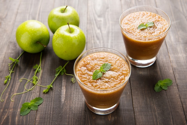 Frischer grüner Apfel-Smoothie auf hölzernem Hintergrund