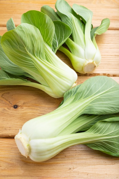 Frischer grüner Bok Choy oder Pac Choi Chinakohl auf braunem Holzhintergrund Seitenansicht