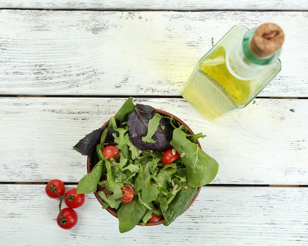 Frischer grüner Salat in der Schüssel auf Holztisch