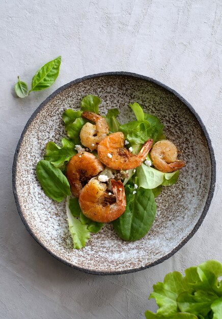 Frischer grüner Salat mit gebratenen Garnelen und Zitrone Basilikumblätter Nahaufnahme Teller mit Kopie Raum Top vie