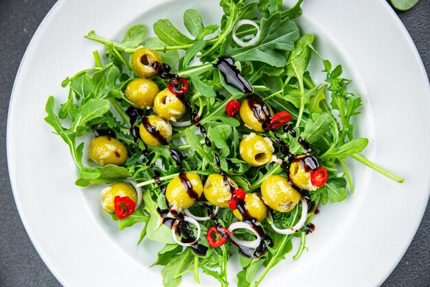 Frischer grüner Salat, Oliven-Chili-Pfeffer, grüner Mix-Salat, Rucola-Mahlzeit, Snack auf dem Tisch