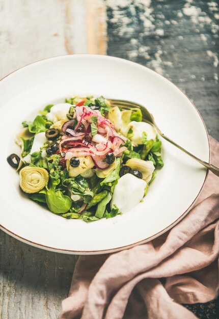 Frischer grüner Sommersalat über selektivem Fokus des hölzernen gemalten Hintergrundes