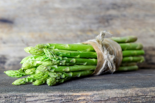 Frischer grüner Spargel auf hölzernem Hintergrund