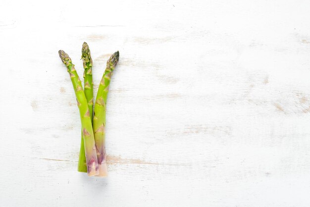 Frischer grüner Spargel auf weißem Holzhintergrund Gesunde Ernährung Draufsicht Freier Platz für Ihren Text