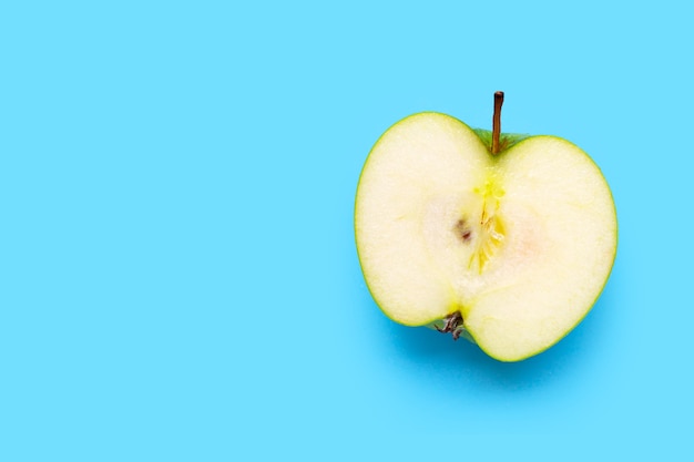 Frischer halber grüner Apfel auf blauem Hintergrund. Draufsicht