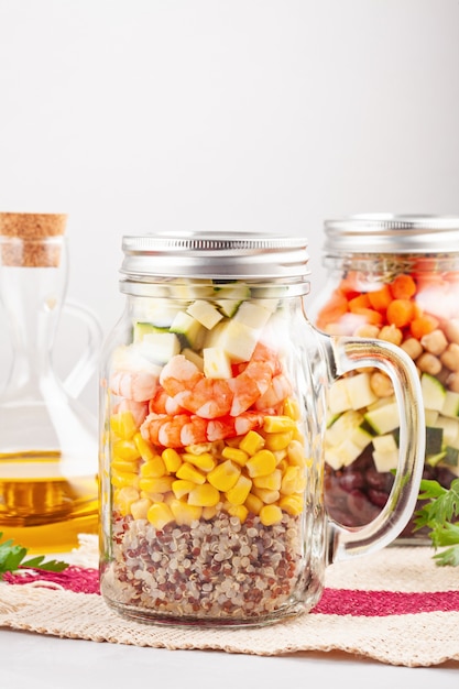 Frischer hausgemachter Salat in Gläsern mit Quinoa, Kichererbsen und Bio-Gemüse. Gesund nehmen Sie Lebensmittel, Büromittagessen, Vegetarier, Detoxdiätkonzept weg.